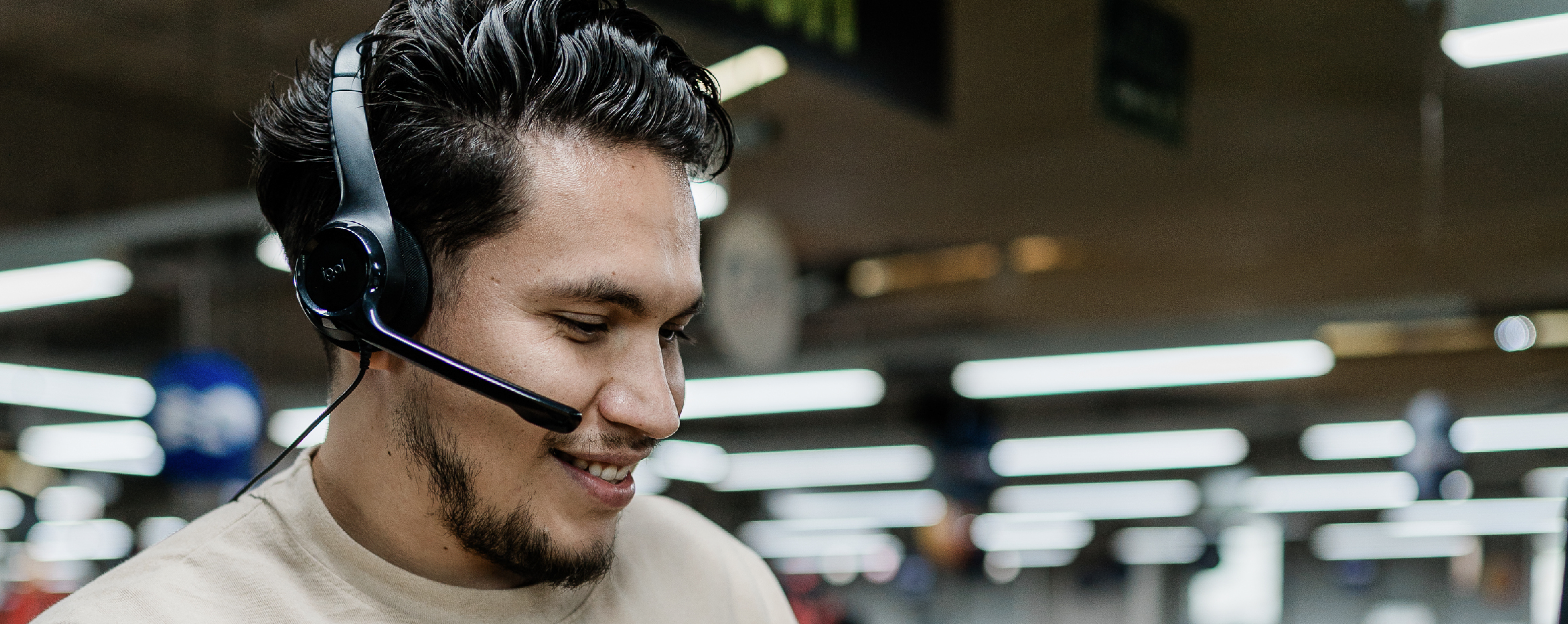 Male contact center worker wearing a headset in the middle of a call.