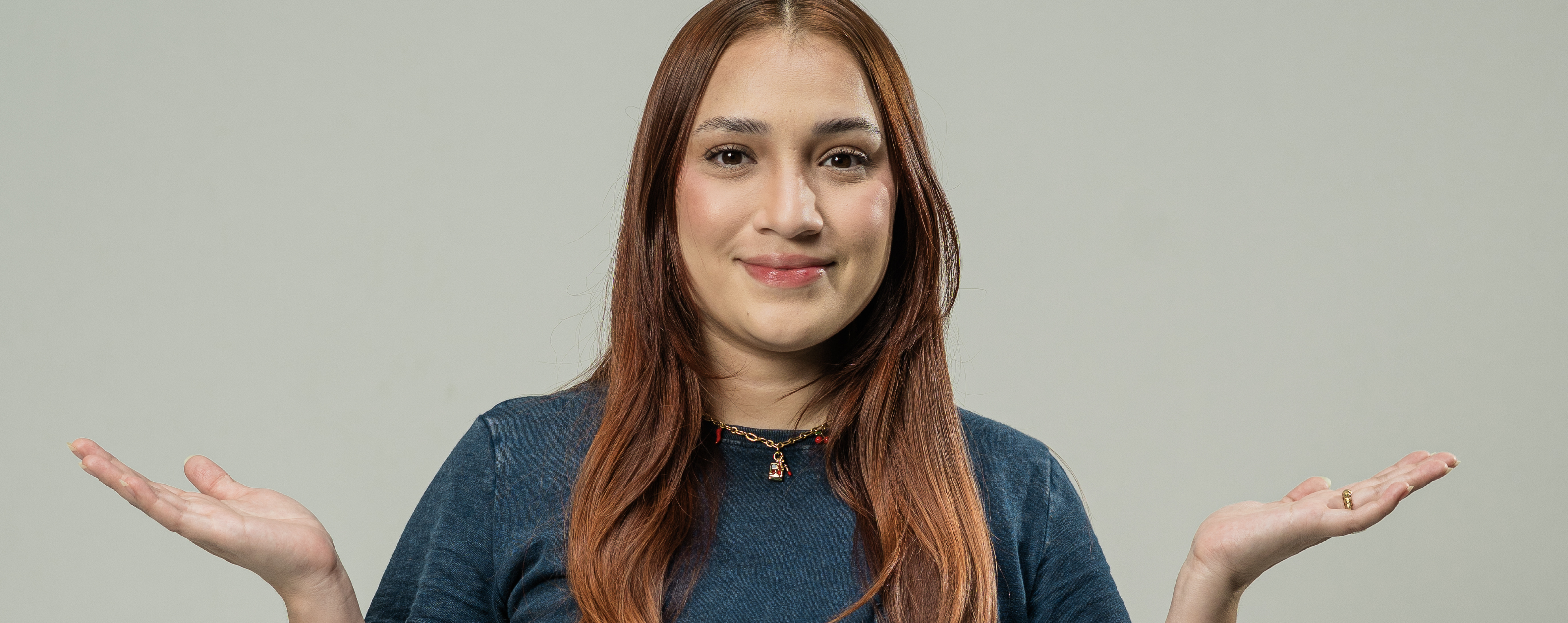 Smiling girl shrugging shoulders, likely wondering what outsourcing is.