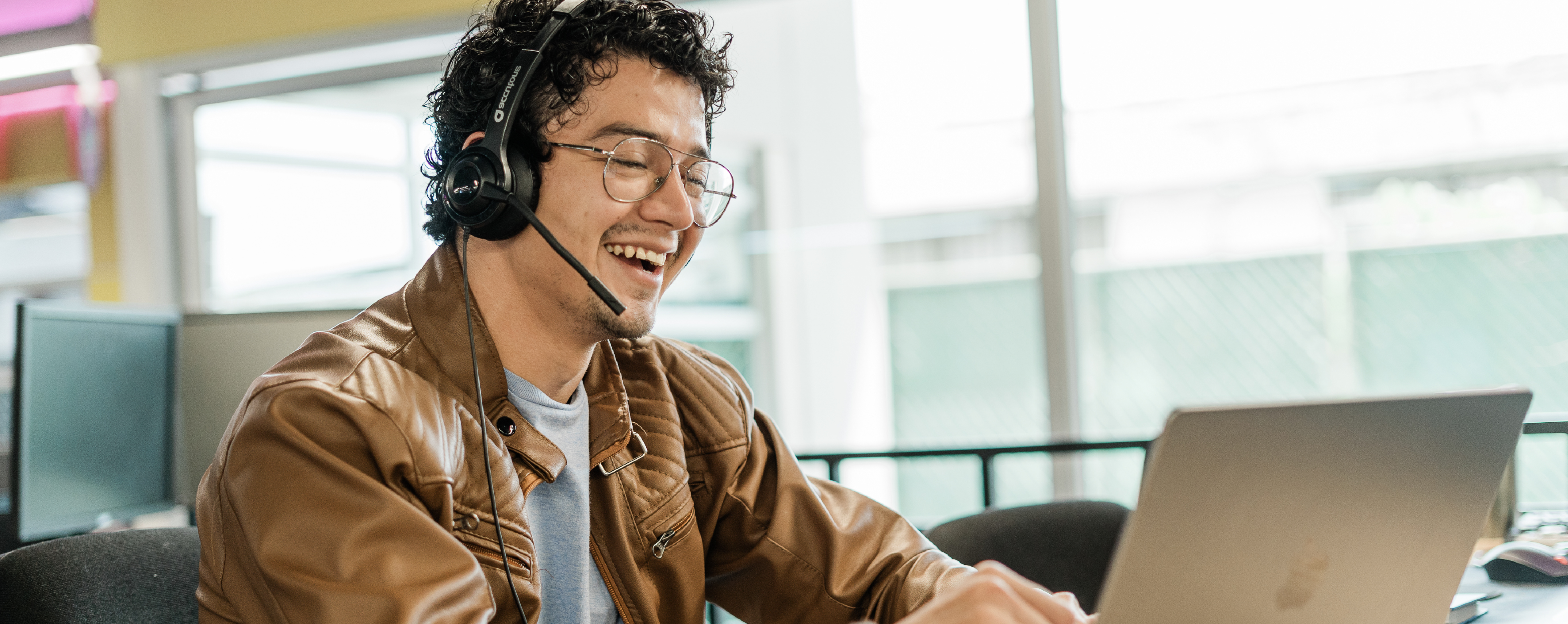 Male contact center worker wearing a headset in the middle of a call.