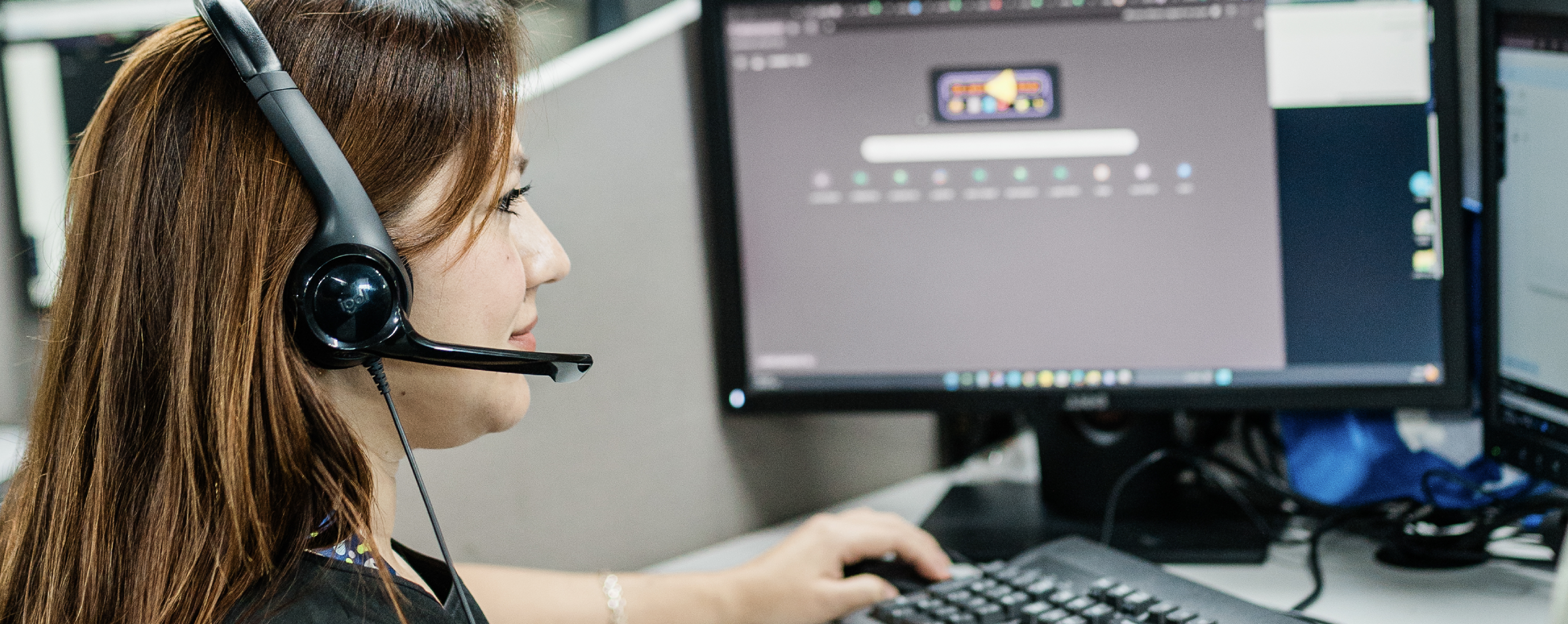 Contact center employee at her desk assisting customers.