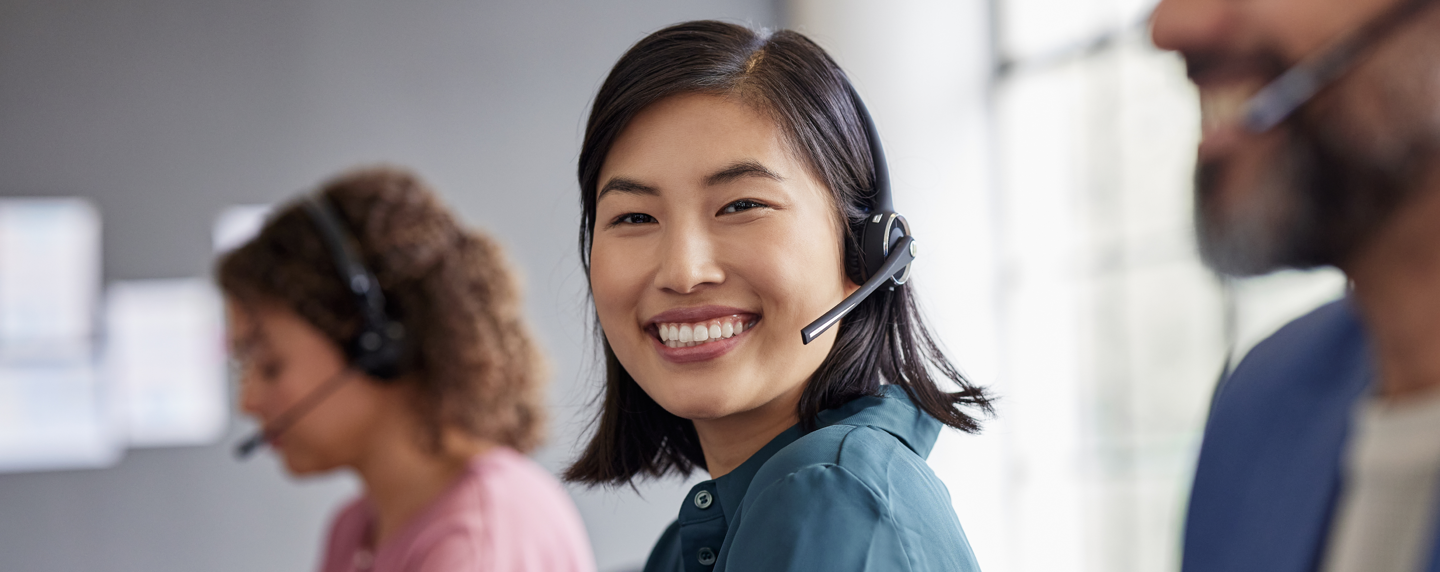 Smiling woman wearing a headset at a contact center