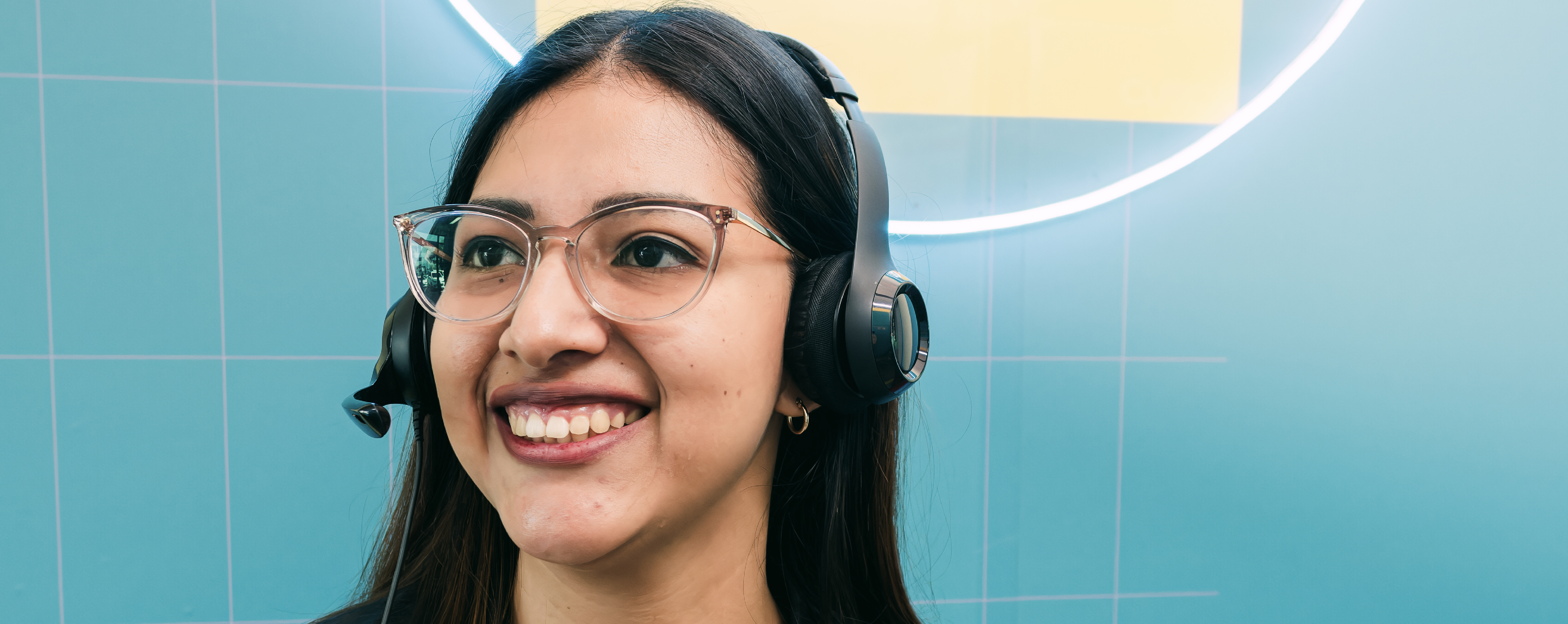 Contact center employee smiling while helping a customer on a call.
