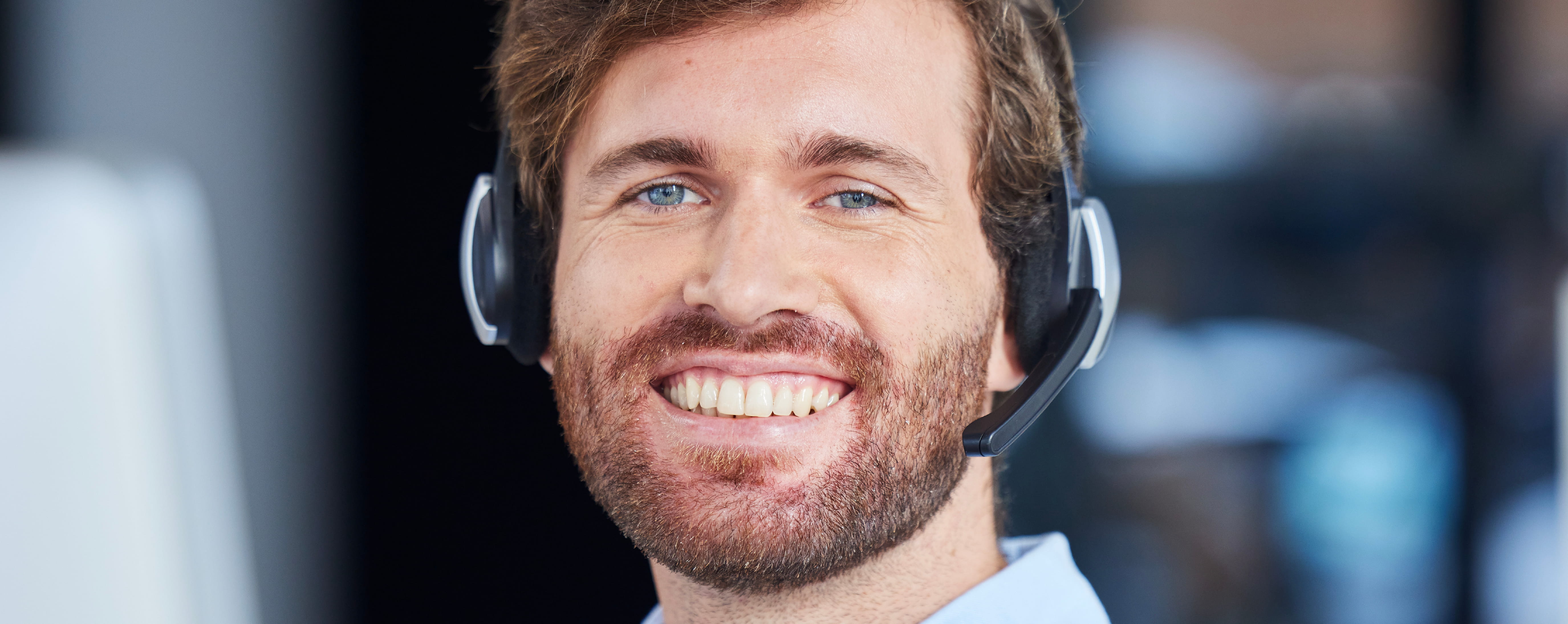 Call center agent smiling while wearing a headset