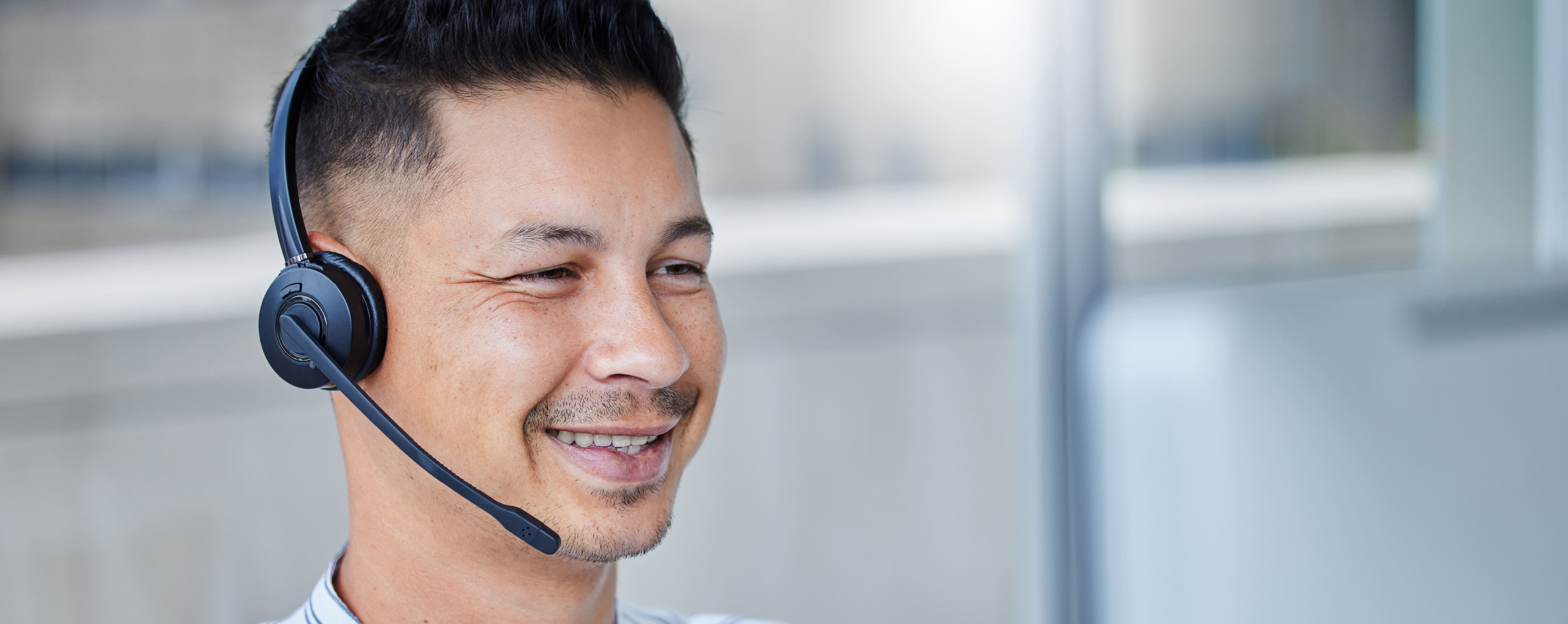 Happy contact center agent smiling with a headset on.