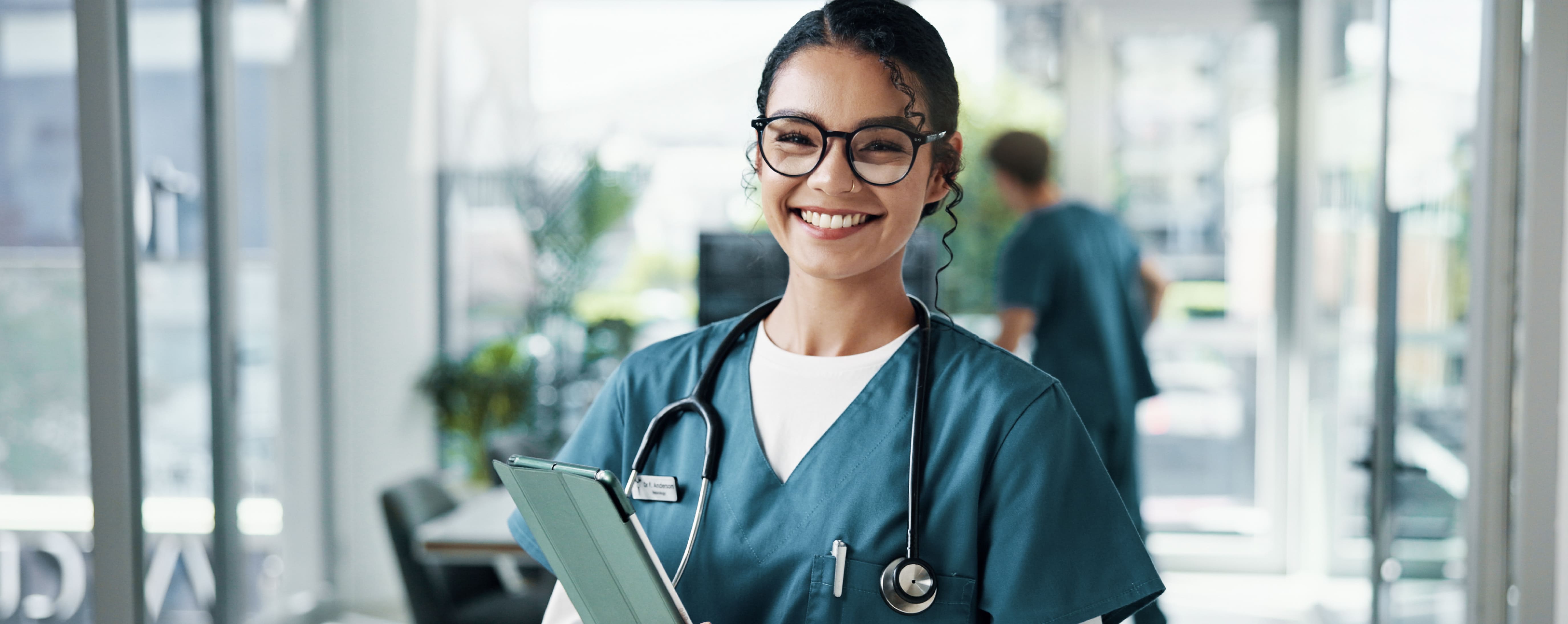 Smiling healthcare worker wearing scrubs.