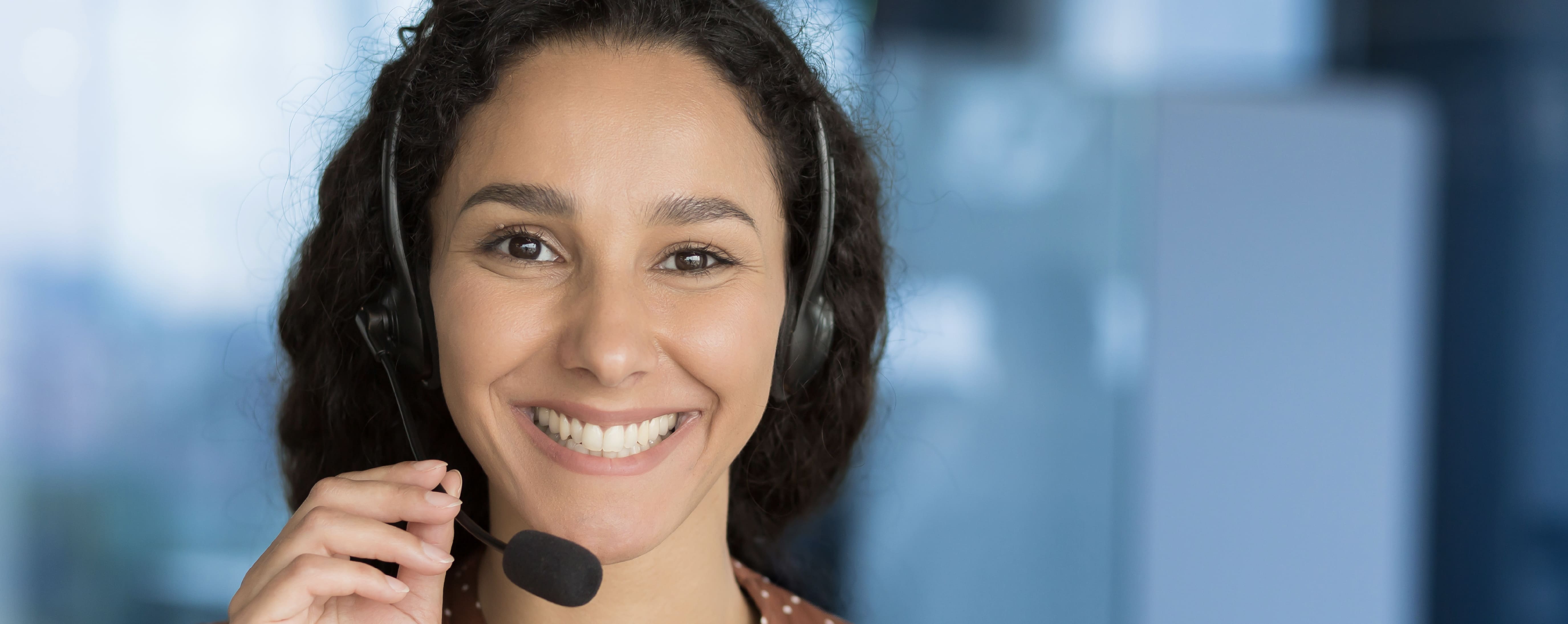 Happy call center agent on a call with headset on.