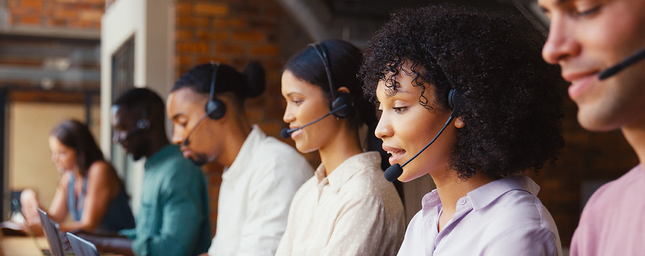 Contact center agents wearing headsets assist customers side by side