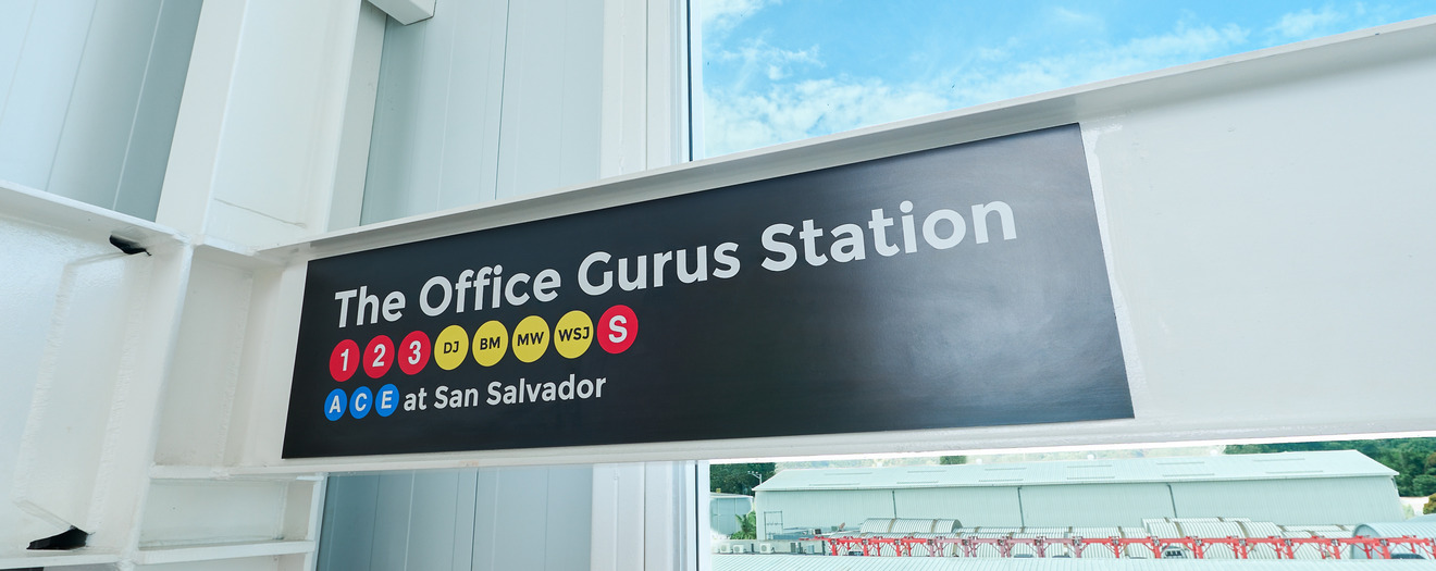 "The Office Gurus Station" subway-style sign at the company's San Salvador office entrance.