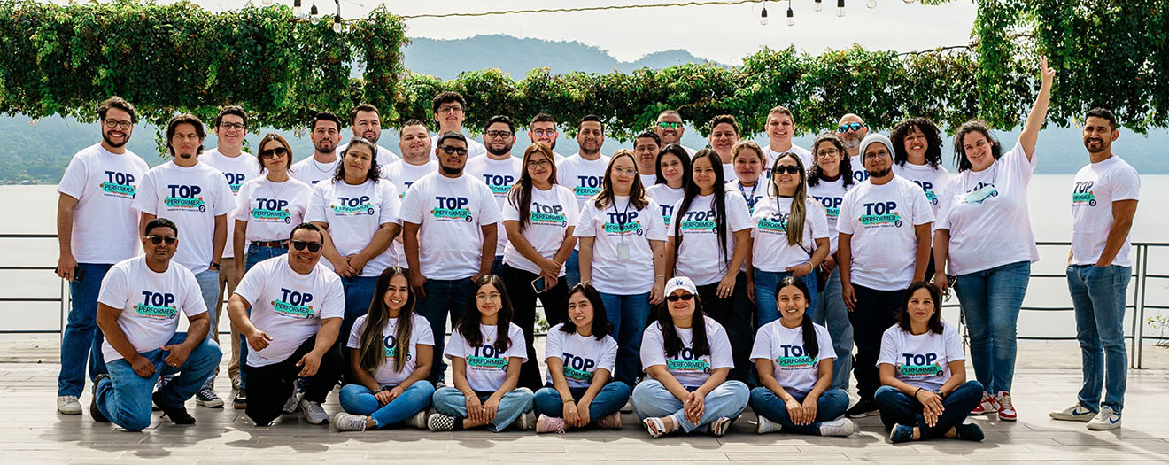 The Office Gurus employees in matching Top Performer T-shirts pose together outdoors